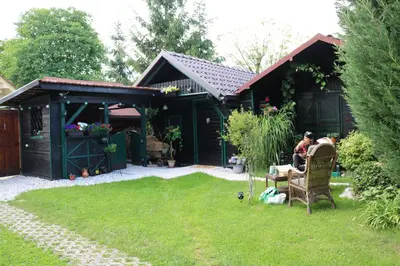 a woman sitting in a chair in a garden at Frenkcottage 5 KM FROM THE AIRPORT- FREE TRANSPORTATION TO THE AIRPORT in Šenčur