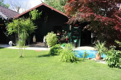 a house with a yard with a pool in front of it at Frenkcottage 5 KM FROM THE AIRPORT- FREE TRANSPORTATION TO THE AIRPORT in Šenčur