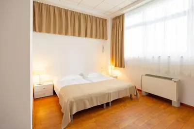 a bedroom with a bed and a large window at Garni Hotel Azul in Kranj