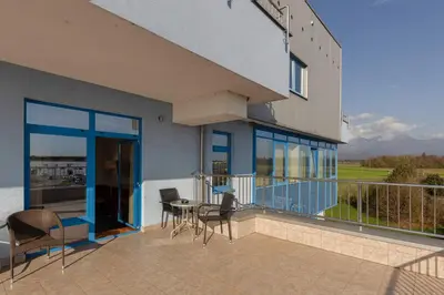 a balcony with a table and chairs and a building at Garni Hotel Azul in Kranj