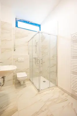 a bathroom with a shower and a toilet and a sink at Garni Hotel Azul in Kranj