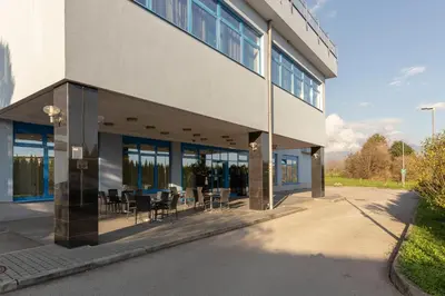 a building with tables and chairs outside of it at Garni Hotel Azul in Kranj