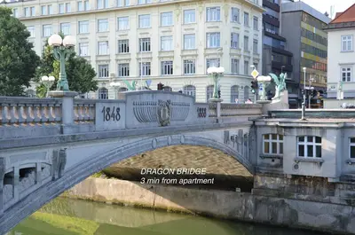 a bridge over a river in front of a building at i Design Studio in Ljubljana