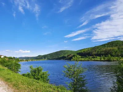 a view of a river with mountains in the background at Holiday Home Neokrnjena Narava in Sevnica
