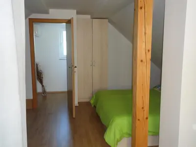 a bedroom with a green bed and a closet at Holiday Home Neokrnjena Narava in Sevnica