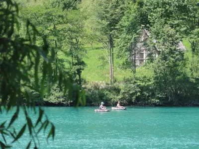 two people are riding on tubes in the water at Apartma Jezero in Most na Soči