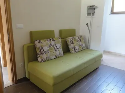 a green couch with two pillows on it in a room at Apartma Jezero in Most na Soči