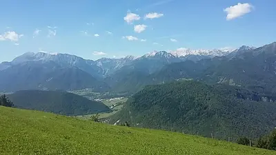 a view of a green hill with mountains in the background at Apartma Jezero in Most na Soči