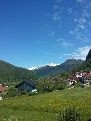 a town in a field with mountains in the background at Apartma Jezero in Most na Soči
