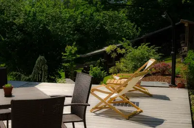 a group of chairs sitting on a wooden deck at Apartmaji Rajska Ptica in Bled