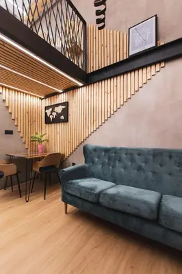 a living room with a blue couch and a table at Gami Ex-Factory Lofts in Ljubljana