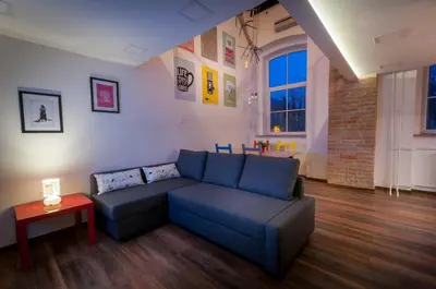 a living room with a blue couch and a table at Gami Ex-Factory Lofts in Ljubljana
