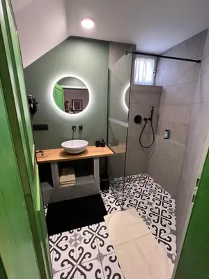 a bathroom with a sink and a shower with a mirror at Apartments Kokl - Adults only in Radovljica