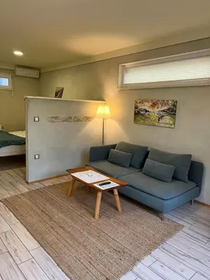 a living room with a blue couch and a table at Apartments Kokl - Adults only in Radovljica