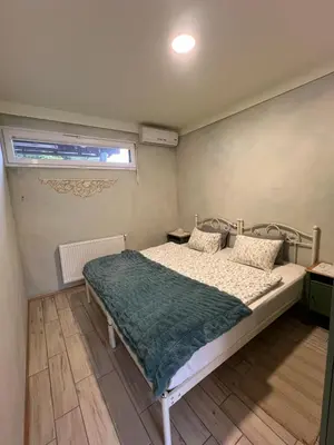 a bedroom with a bed with a green blanket on it at Apartments Kokl - Adults only in Radovljica