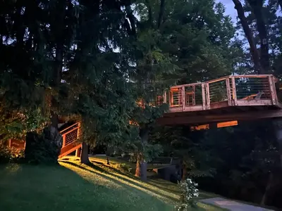 a tree house with a bridge in a yard at Apartments Kokl - Adults only in Radovljica