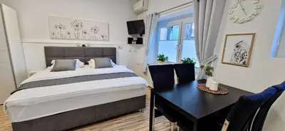 a bedroom with a bed and a table and a clock at Apartment Mario in Ptuj