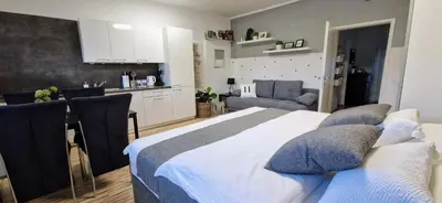 a bedroom with a large bed and a kitchen at Apartment Mario in Ptuj