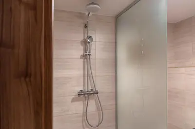 a shower with a shower head in a bathroom at Vila Marin Miler in Prevalje