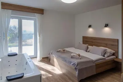a bedroom with a bed and a tub in it at Vila Marin Miler in Prevalje
