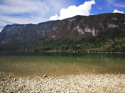 a body of water with a mountain in the background at Planika B&M in Bohinj
