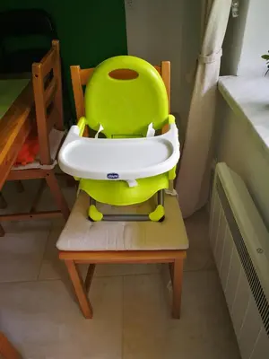 a green and white chair sitting on a wooden chair at Planika B&M in Bohinj
