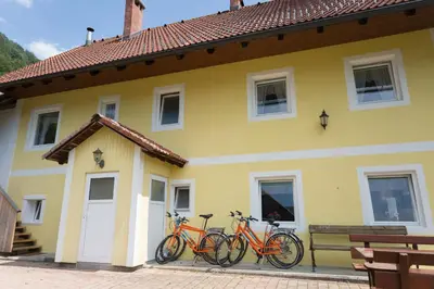three bikes parked on the side of a yellow house at Apartment House Andrej in Bohinj