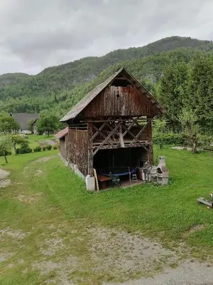 an old barn in the middle of a field at Apartment House Andrej in Bohinj