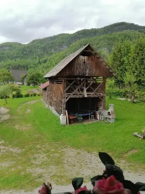 an old barn in the middle of a field at Apartment House Andrej in Bohinj