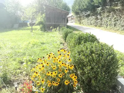 a garden with sunflowers in a yard with a building at Apartment House Andrej in Bohinj