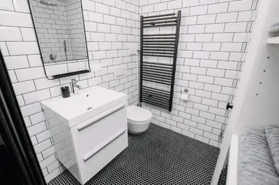 a white bathroom with a sink and a toilet at Hanna's suite with free parking in Ljubljana