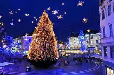 a christmas tree in the middle of a city at night at Hanna's suite with free parking in Ljubljana