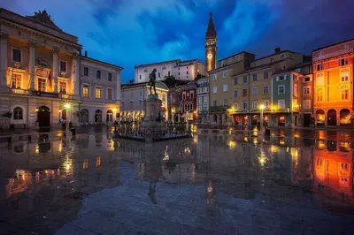 a city square with a clock tower at night at Hanna's suite with free parking in Ljubljana