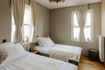 two beds in a room with two windows at Rooms VERDE in Petrovče