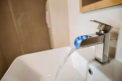 a sink with water coming out of a faucet at Rooms VERDE in Petrovče