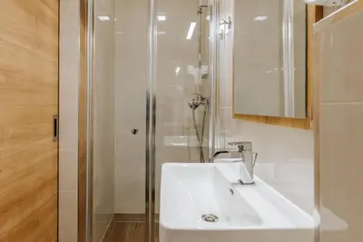 a white bathroom with a sink and a shower at Rooms VERDE in Petrovče