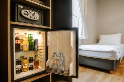 a refrigerator filled with lots of drinks and a bed at Rooms VERDE in Petrovče
