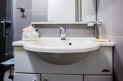 a bathroom with a white sink and a mirror at Rooms VERDE in Petrovče