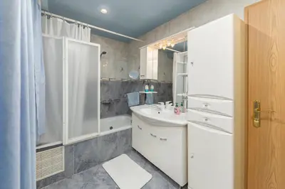 a bathroom with a white sink and a shower at Apartma Franko in Cerklje na Gorenjskem