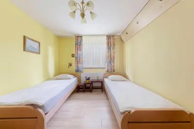 two beds in a room with yellow walls at Apartma Franko in Cerklje na Gorenjskem
