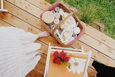 a picnic table with a basket of beach items and a table with a bed at Panorama Glamping Visole in Slovenska Bistrica
