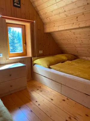 a bedroom with two beds in a log cabin at Cosy Chalet on Pokljuka - Brunarica Tinkara in Zgornje Gorje