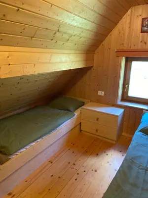 a bedroom in a log cabin with a bunk bed at Cosy Chalet on Pokljuka - Brunarica Tinkara in Zgornje Gorje