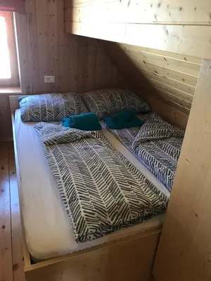 a bunk bed with two pillows on top of it at Cosy Chalet on Pokljuka - Brunarica Tinkara in Zgornje Gorje