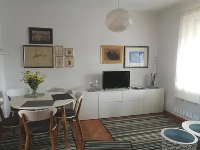 a living room with a table and a tv at City center blue sky house in Postojna
