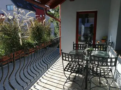 a patio with a table and chairs on a building at City center blue sky house in Postojna