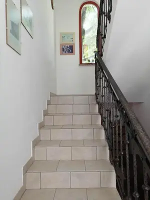 a staircase in a house with white walls and a window at City center blue sky house in Postojna