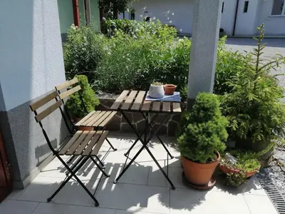 a table and a bench on a patio with plants at City center blue sky house in Postojna