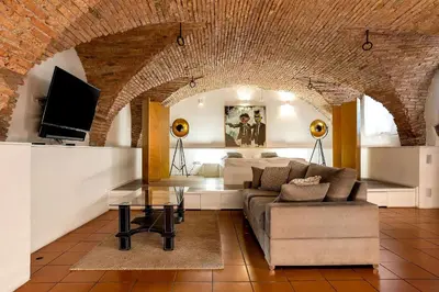 a living room with a couch and a tv at Dungeon Apartment in Ljubljana