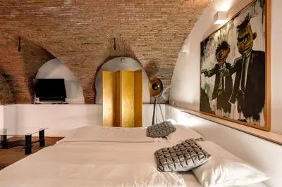 a bedroom with a bed and a brick wall at Dungeon Apartment in Ljubljana